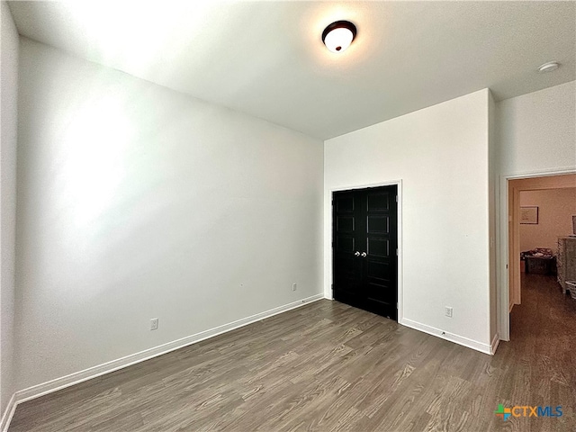 unfurnished bedroom with dark hardwood / wood-style flooring