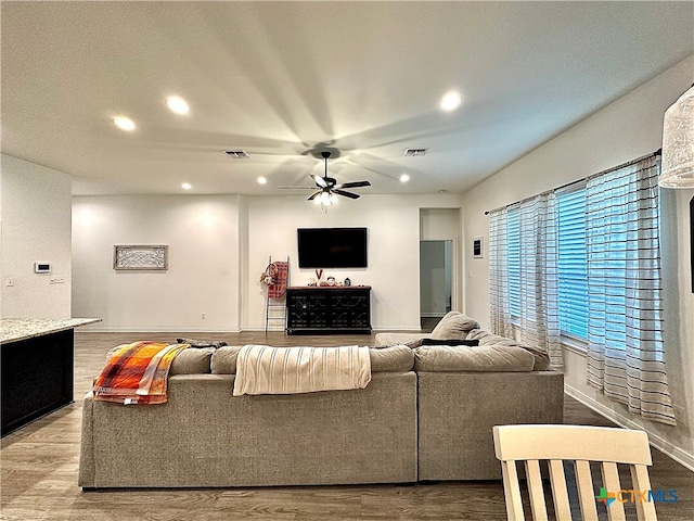 living room featuring wood-type flooring and ceiling fan