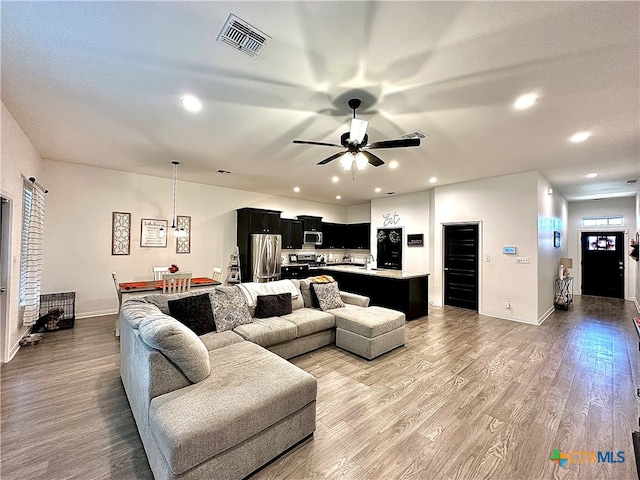 living room featuring ceiling fan and light hardwood / wood-style flooring