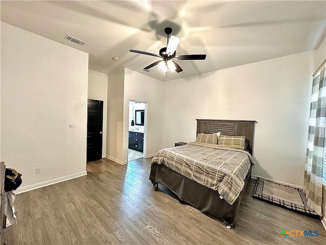 bedroom featuring connected bathroom, wood-type flooring, and ceiling fan