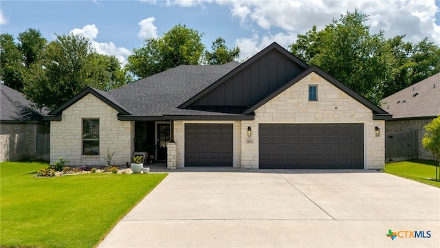 2823 Pistoia Trl, Temple, TX 76502 - view of front facade featuring board and batten siding, a garage, stone siding, a front yard, and driveway
