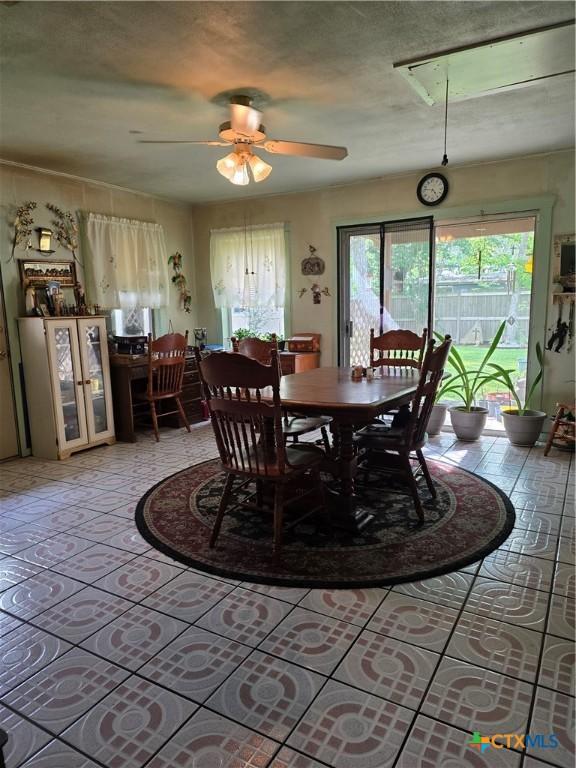 dining room with a ceiling fan, light tile patterned floors, and a wealth of natural light