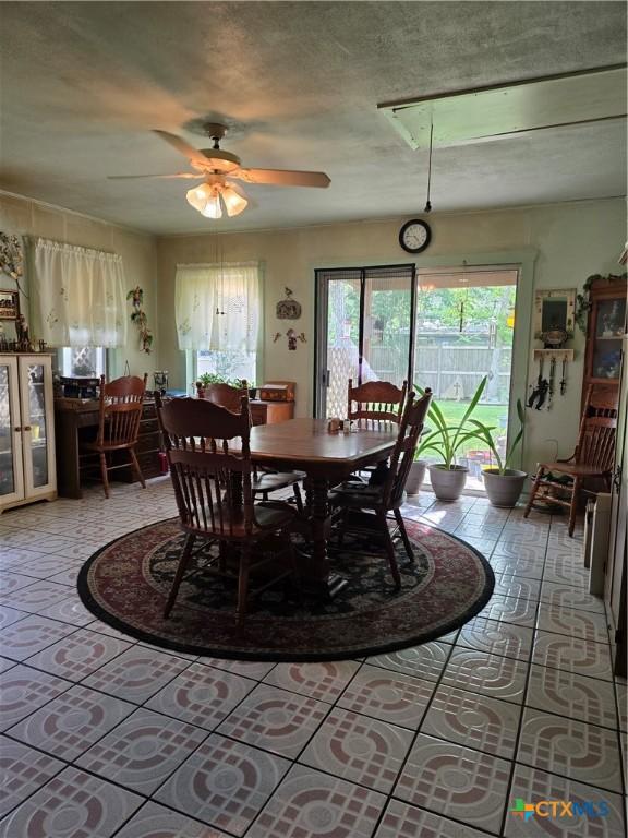 dining space with light tile patterned floors, plenty of natural light, and ceiling fan