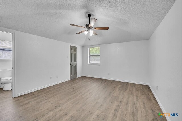 2316 Schwertner Dr, Killeen, TX 76543 - unfurnished bedroom featuring a textured ceiling, wood finished floors, vaulted ceiling, a ceiling fan, and ensuite bath