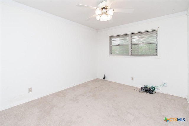 carpeted spare room featuring ornamental molding and ceiling fan