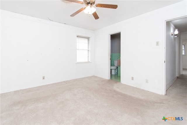 carpeted spare room with ceiling fan and crown molding