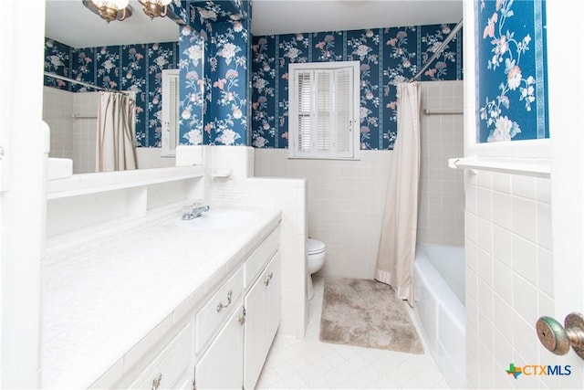 full bathroom featuring toilet, tile walls, tile patterned floors, shower / tub combo, and vanity