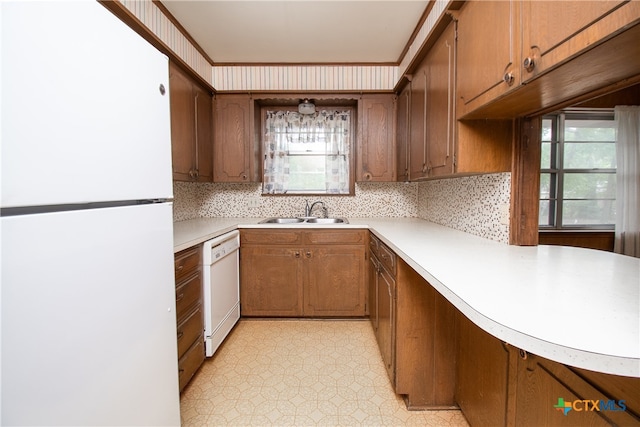 kitchen featuring white appliances, decorative backsplash, and sink