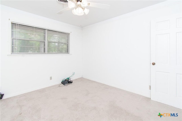 carpeted empty room with ceiling fan and crown molding