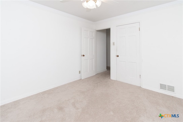 carpeted empty room featuring ceiling fan and ornamental molding