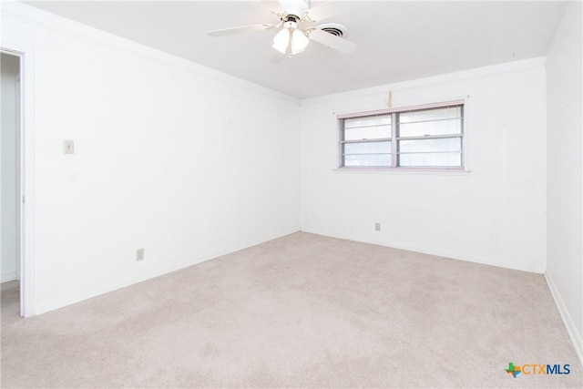 carpeted spare room featuring ornamental molding and ceiling fan