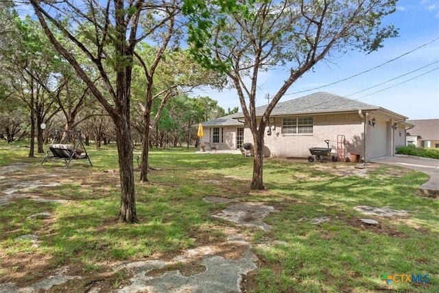 15938 Goliad Loop, Temple, TX 76502 - view of grassy yard featuring an attached garage and concrete driveway