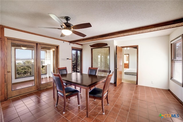 dining room featuring ceiling fan, tile patterned flooring, a healthy amount of sunlight, and a textured ceiling