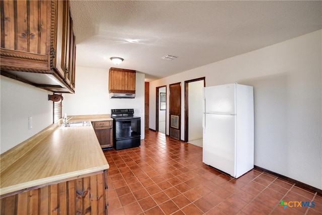 kitchen with ventilation hood, white refrigerator, sink, black electric range, and a textured ceiling