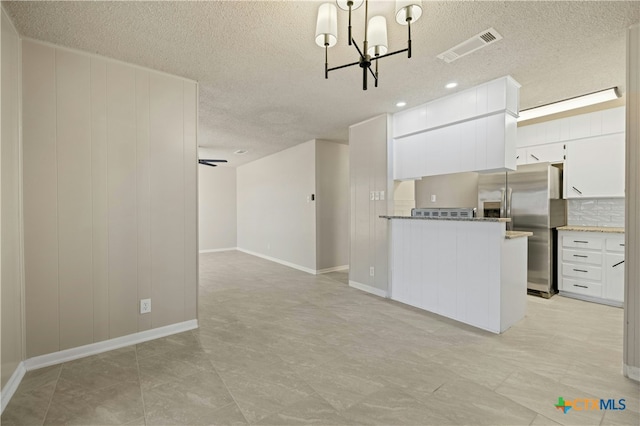 kitchen featuring visible vents, white cabinets, decorative backsplash, stainless steel fridge with ice dispenser, and a chandelier