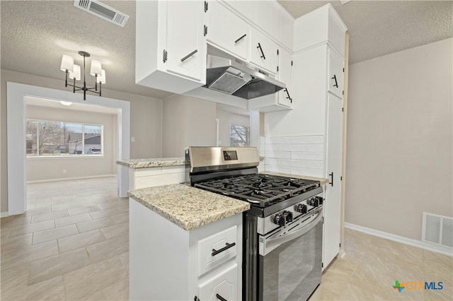 kitchen with under cabinet range hood, stainless steel gas range oven, visible vents, and backsplash