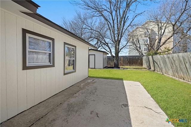 view of yard with a patio area, a fenced backyard, and an outbuilding