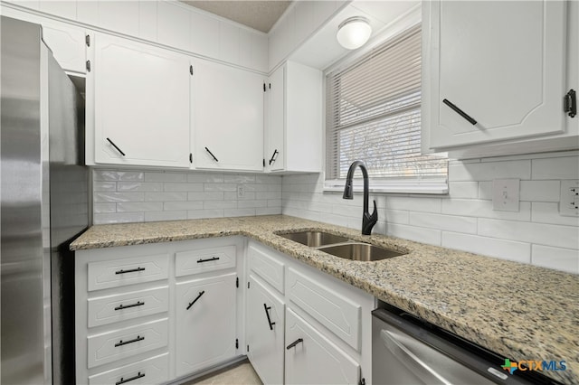 kitchen with white cabinetry, appliances with stainless steel finishes, decorative backsplash, and a sink