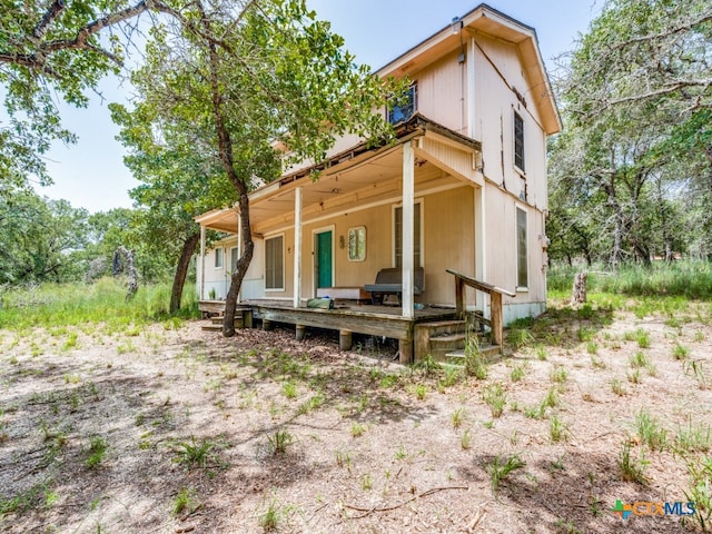 rear view of property featuring covered porch