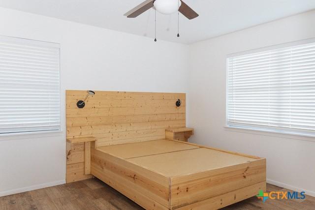 bedroom featuring wood finished floors, baseboards, and a ceiling fan