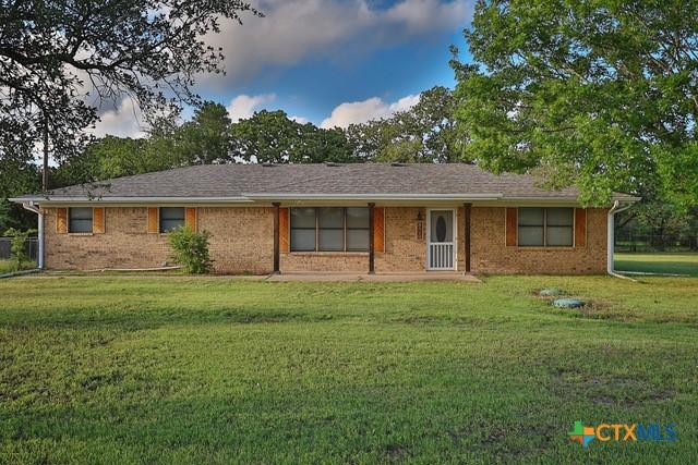 ranch-style house featuring a front yard and brick siding
