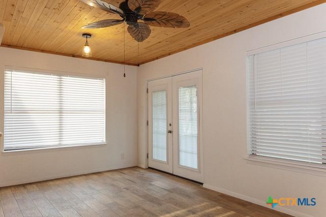 entryway with wooden ceiling, french doors, wood finished floors, ceiling fan, and healthy amount of natural light