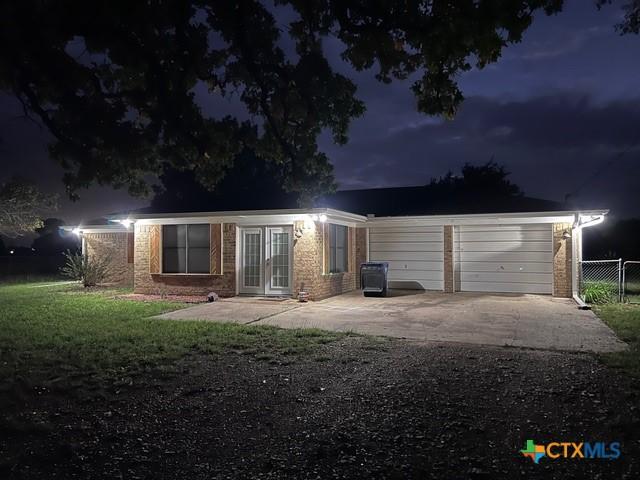garage at twilight with fence and french doors