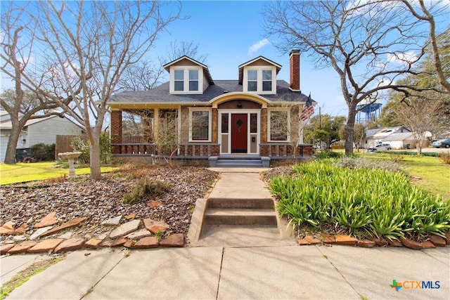 view of front of house with brick siding and a chimney