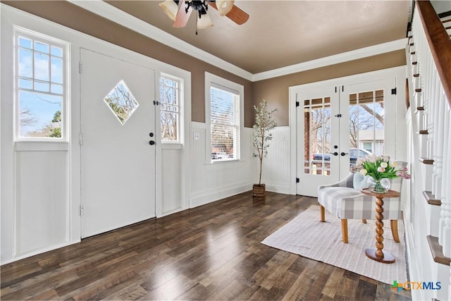 foyer featuring ceiling fan, wood finished floors, french doors, wainscoting, and crown molding