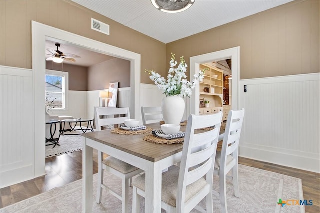 dining space with ceiling fan, wood finished floors, and visible vents