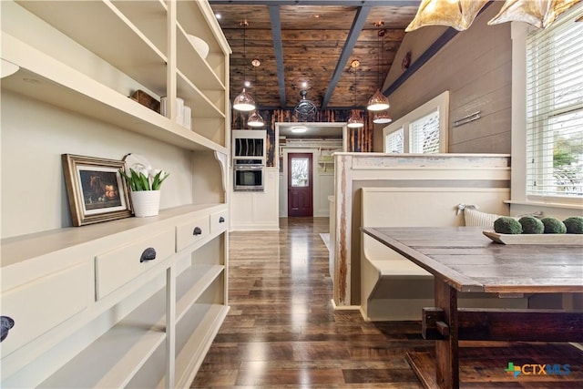 corridor featuring dark wood-style flooring, a healthy amount of sunlight, vaulted ceiling, and wooden ceiling