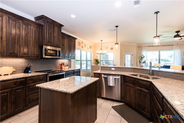 1729 Yturria Dr, Belton, TX 76513 - kitchen featuring appliances with stainless steel finishes, light tile patterned floors, a sink, backsplash, and crown molding