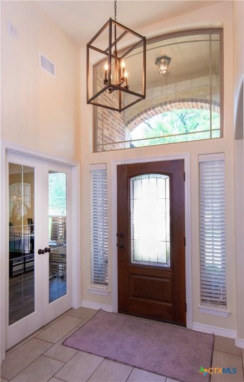 1729 Yturria Dr, Belton, TX 76513 - entryway with a chandelier, light tile patterned flooring, a towering ceiling, baseboards, and french doors