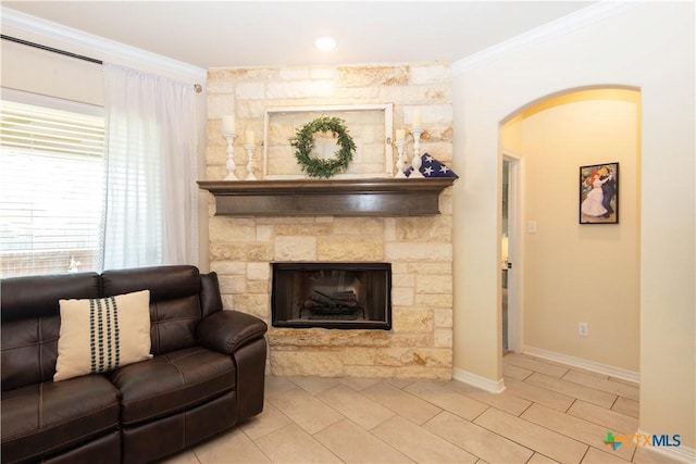 1729 Yturria Dr, Belton, TX 76513 - living room featuring ornamental molding, arched walkways, light tile patterned floors, baseboards, and a fireplace