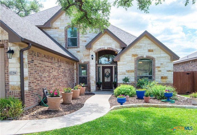 1729 Yturria Dr, Belton, TX 76513 - property entrance featuring stone siding, roof with shingles, fence, and brick siding