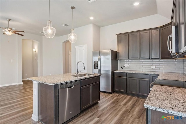1202 Amber Dawn Dr, Temple, TX 76502 - kitchen with appliances with stainless steel finishes, arched walkways, light wood-type flooring, dark brown cabinetry, and recessed lighting