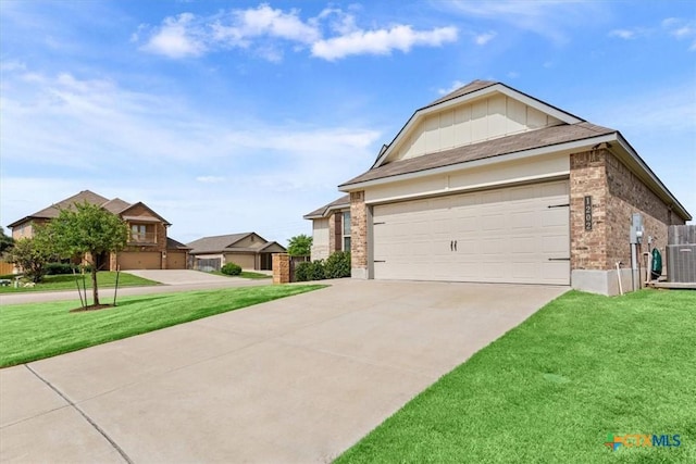 1202 Amber Dawn Dr, Temple, TX 76502 - view of front facade with a front yard, driveway, brick siding, a garage, and board and batten siding