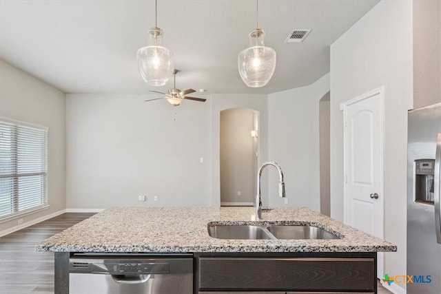 1202 Amber Dawn Dr, Temple, TX 76502 - kitchen featuring stainless steel appliances, arched walkways, a ceiling fan, dark wood-type flooring, and an island with sink