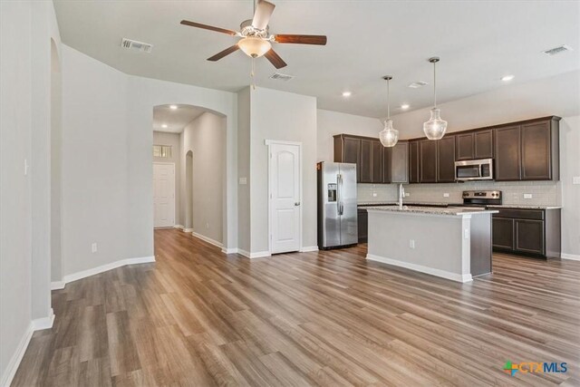 1202 Amber Dawn Dr, Temple, TX 76502 - kitchen featuring appliances with stainless steel finishes, arched walkways, ceiling fan, decorative backsplash, and dark brown cabinetry