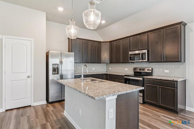 1202 Amber Dawn Dr, Temple, TX 76502 - kitchen featuring stainless steel appliances, dark brown cabinetry, wood finished floors, tasteful backsplash, and light stone counters
