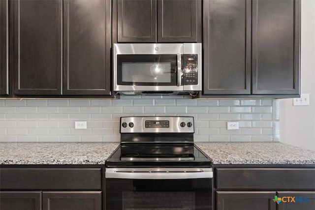 1202 Amber Dawn Dr, Temple, TX 76502 - kitchen with appliances with stainless steel finishes, dark brown cabinetry, tasteful backsplash, and light stone countertops