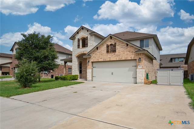 view of front of home with a garage and central air condition unit