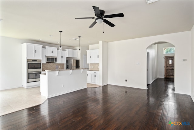 unfurnished living room featuring ceiling fan and light wood-type flooring