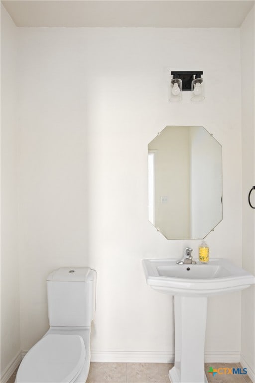 bathroom featuring toilet, sink, and tile patterned floors