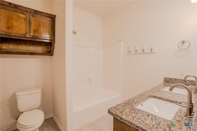 bathroom with shower / bathing tub combination, toilet, double vanity, and a sink