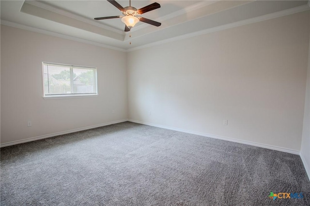 unfurnished room featuring a raised ceiling, ornamental molding, and carpet floors