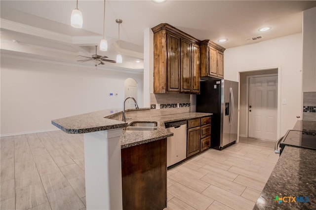 kitchen featuring a sink, visible vents, stainless steel appliances, a peninsula, and a ceiling fan
