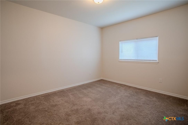 carpeted empty room with baseboards