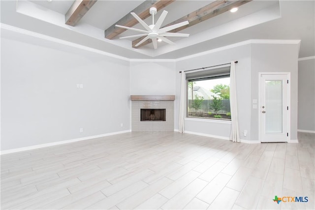 2904 Torino Reale Ave, Temple, TX 76502 - unfurnished living room featuring a ceiling fan, beam ceiling, a fireplace, light wood-style floors, and baseboards