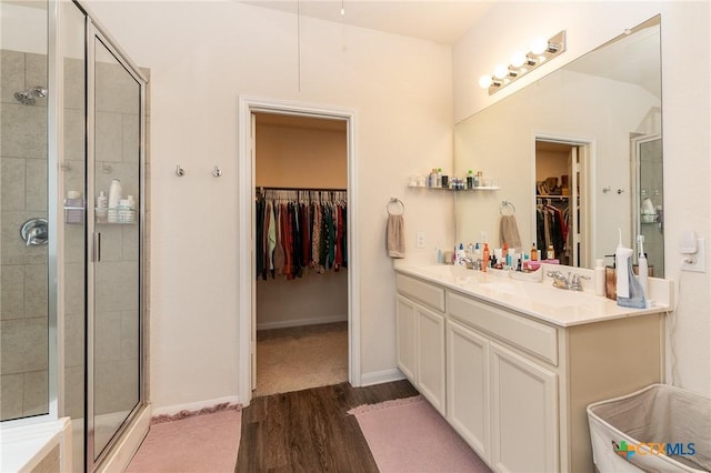 bathroom featuring vanity, wood-type flooring, and walk in shower